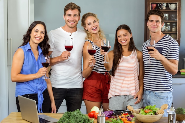 Ritratto degli amici felici che tengono i vetri di vino