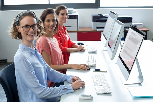 Ritratto degli uomini d'affari sorridenti che lavorano al computer