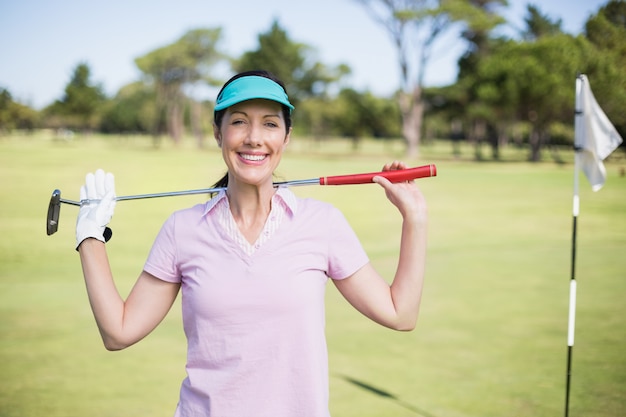 Ritratto del club di golf di trasporto della donna felice