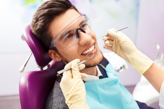 Ritratto del concetto di cura dentale maschile L'ispezione dentale viene data all'uomo circondato dal dentista.