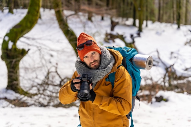 Ritratto del fotografo che si diverte a scattare foto in inverno sulla montagna con l'hobby invernale della neve