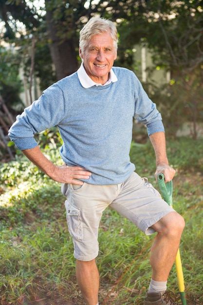 Ritratto del giardiniere felice con lo strumento che sta al giardino