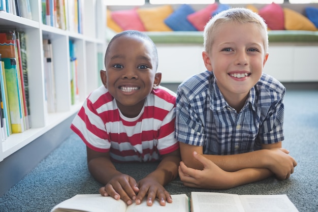 Ritratto del libro di lettura dei bambini della scuola in biblioteca