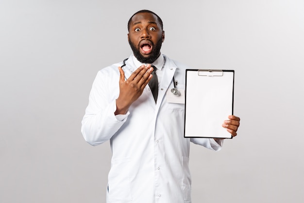 Ritratto del medico o del medico afroamericano in uniforme bianca.