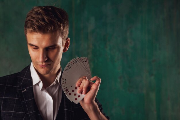 Ritratto del primo piano del giovane con le carte di gioco