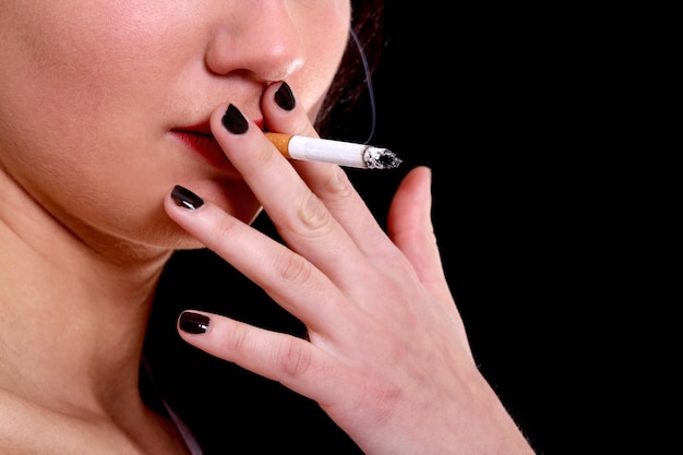 Ritratto del primo piano della donna con la sigaretta sopra black