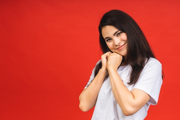 Ritratto del primo piano della donna sorridente felice della ragazza di affari del brunette in casual isolato sopra fondo rosso