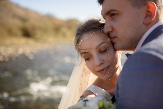 Ritratto del primo piano della sposa e dello sposo un momento prima del bacio.