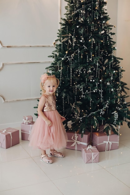 Ritratto del primo piano di bella bambina felice in vestiti eleganti di festa che posano che guarda l'obbiettivo