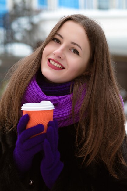 Ritratto del primo piano di bella giovane modella che posa con la tazza di caffè
