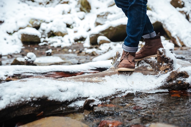 Ritratto del primo piano di gambe maschili con fiume e neve and