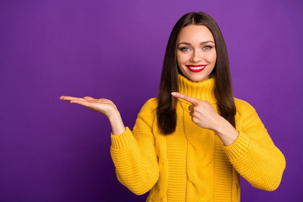 Ritratto del primo piano di lei bella ragazza dai capelli lisci allegra attraente che indica tenendo a portata di mano regalo presente sorpresa.