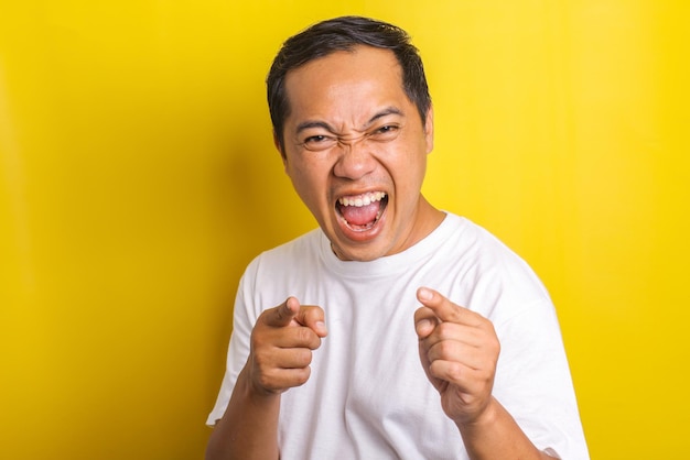 Ritratto del primo piano di un uomo asiatico allegro ed eccitato con entrambe le dita puntate verso la telecamera