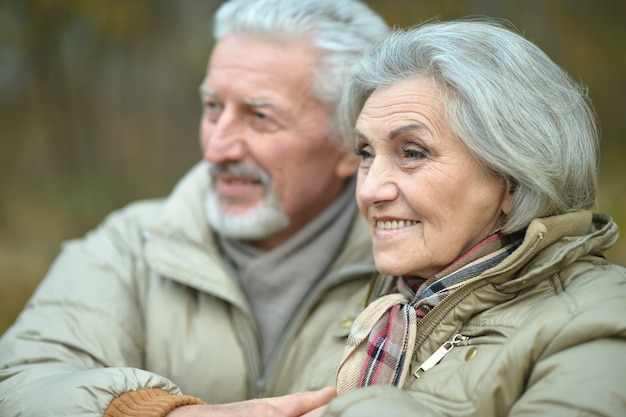 Ritratto del primo piano di una coppia senior sorridente in vestiti caldi all'aperto