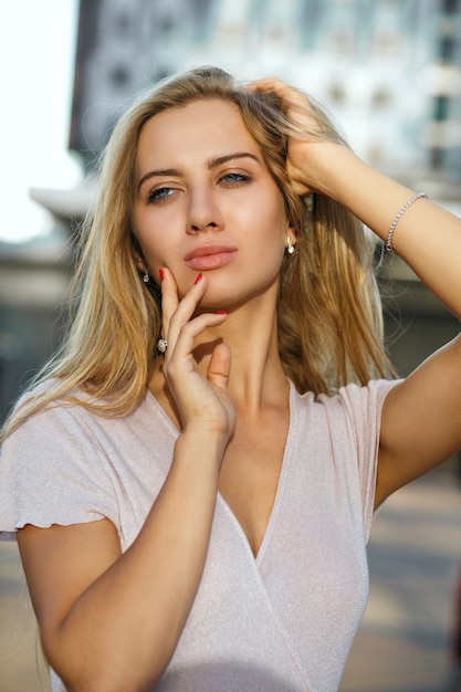 Ritratto del primo piano di una donna glamour dagli occhi azzurri con una pelle perfetta e un trucco naturale