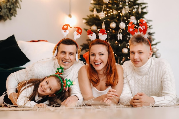 Ritratto del primo piano di una famiglia felice che si trova vicino a un albero di Natale che celebra una vacanza.