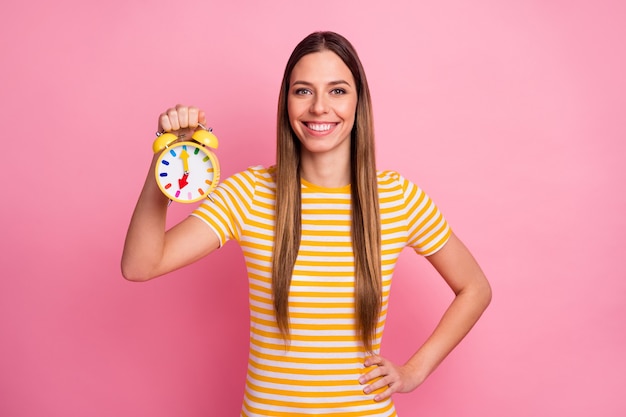 Ritratto del primo piano di una ragazza allegra affascinante che tiene in mano l'orologio