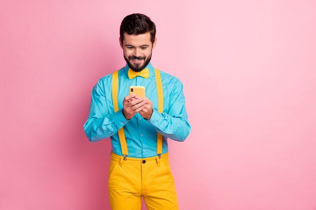 Ritratto del ragazzo barbuto concentrato che tiene la cella in chat