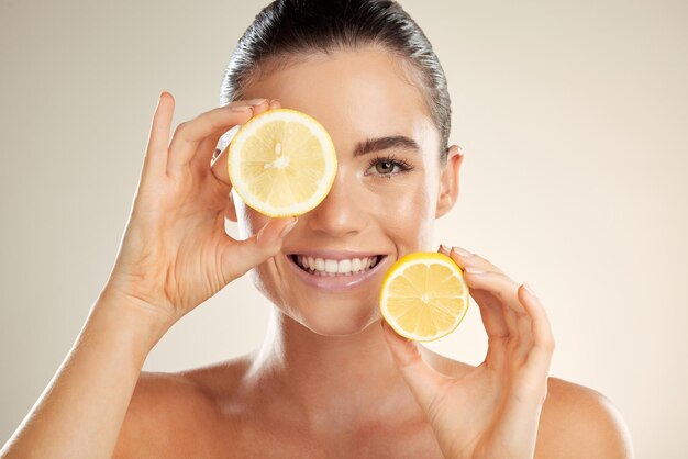 Ritratto del viso per la cura della pelle e donna felice con limone per la disintossicazione della frutta naturale salute benessere o bagliore di bellezza del viso Salone spa dermatologia modello sanitario e nutrizionista con prodotto alimentare alla vitamina c