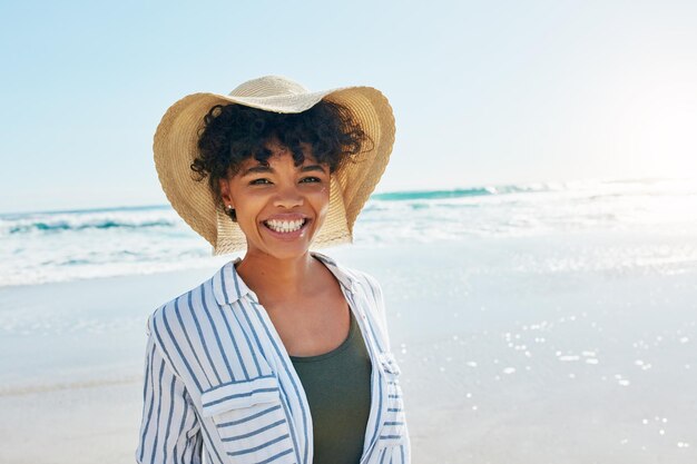 Ritratto del volto di donna ed estate in spiaggia per un viaggio di vacanza o una vacanza con un sorriso Persona di sesso femminile africana in mare con libertà di felicità e mentalità positiva per rilassarsi all'aperto