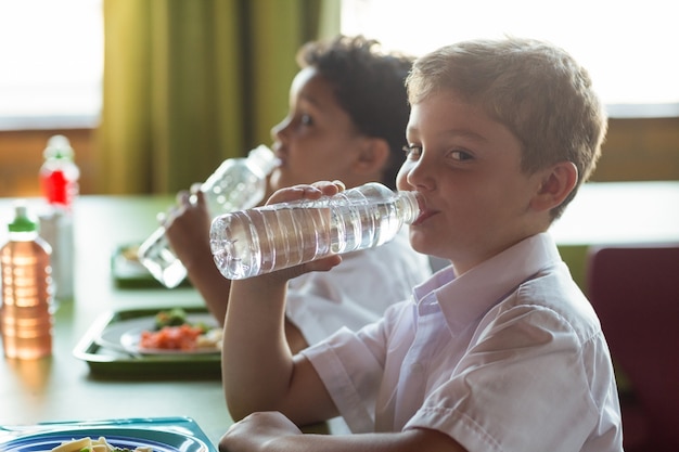 Ritratto dell'acqua potabile dello scolaro dalla bottiglia