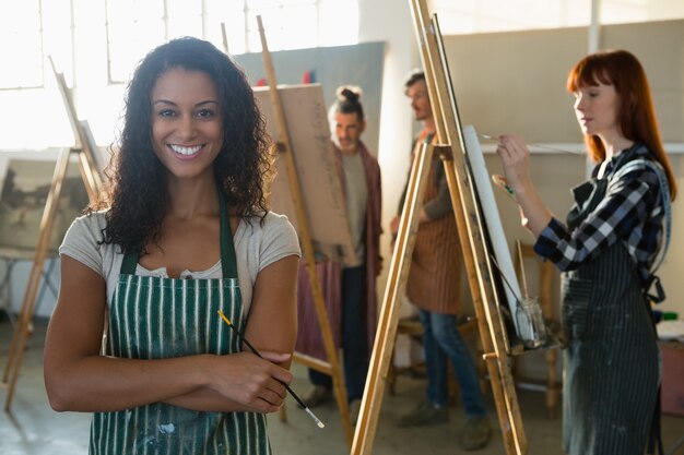 Ritratto dell'artista femminile sorridente con la pittura degli amici