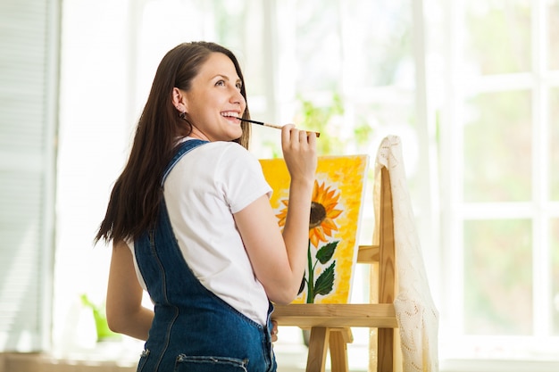 Ritratto dell'artista splendido della donna che dipinge a casa