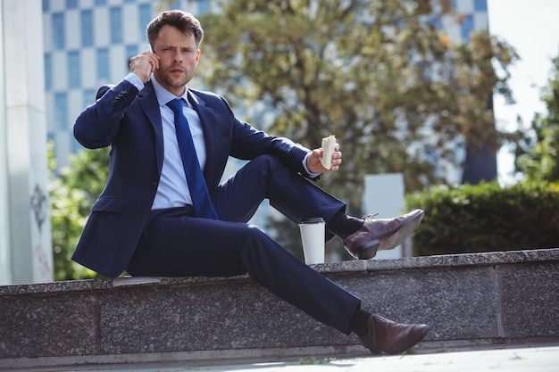 Ritratto dell'uomo d'affari bello che parla sul telefono cellulare