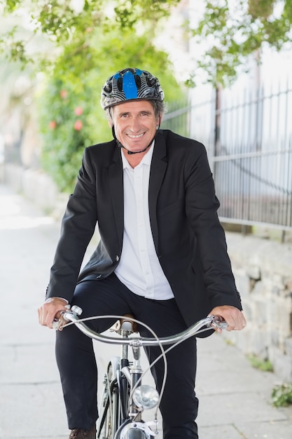 Ritratto dell'uomo d'affari che sorride sulla bicicletta