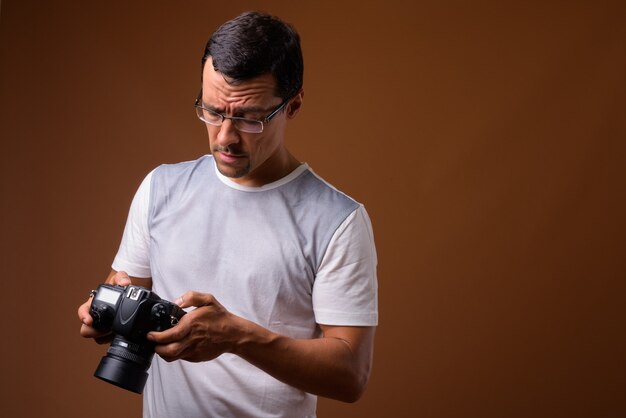 Ritratto dell'uomo del fotografo su colore marrone