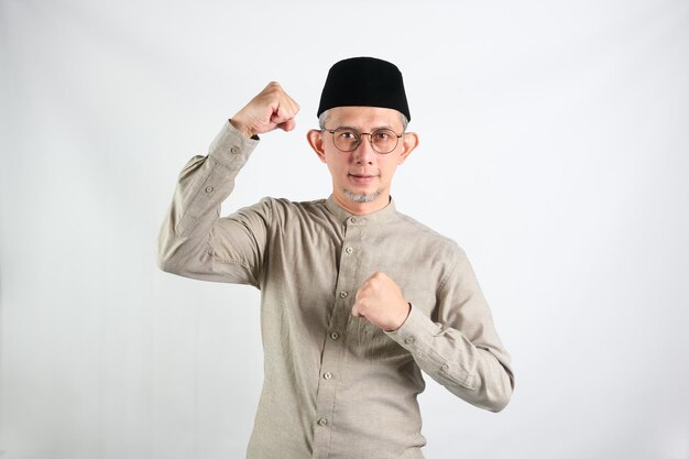 Ritratto dell'uomo musulmano asiatico con un'espressione vivace che celebra il successo