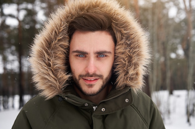 Ritratto dell'uomo si chiuda nella foresta di inverno