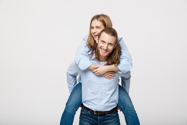 Ritratto dell&#39;uomo sorridente che dà a donna felice un giro sulle spalle.