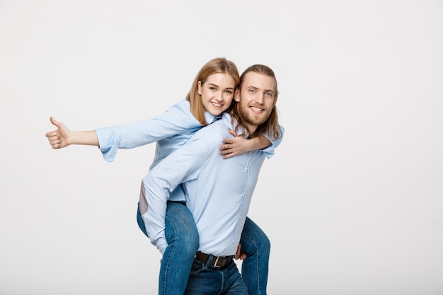 Ritratto dell&#39;uomo sorridente che dà a donna felice un giro sulle spalle.