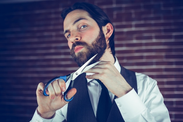 Ritratto della barba di taglio della tenuta dell&#39;uomo con le forbici