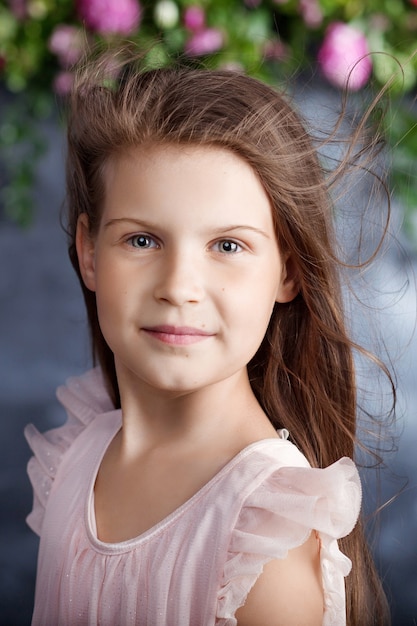 Ritratto della bella bambina con un mazzo di fiori. Vento nei capelli