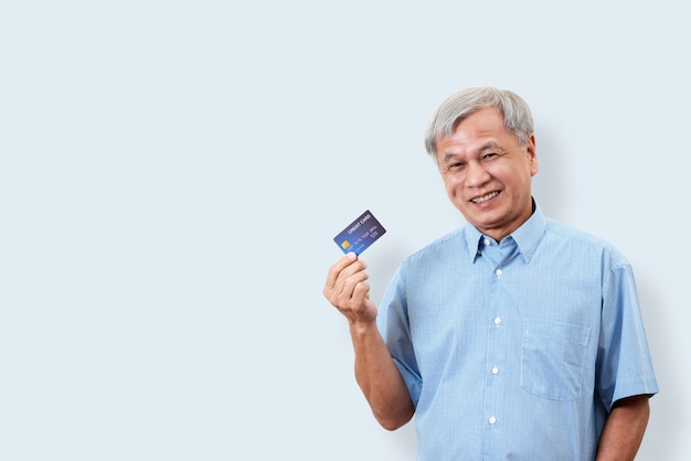 Ritratto della carta di credito asiatica senior felice della tenuta dell&#39;uomo