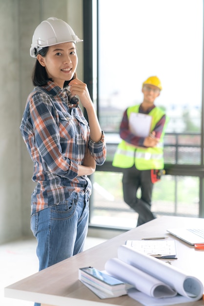 Ritratto della donna asiatica dell&#39;architetto con il costume casuale sul sito di rinnovamento della casa della costruzione