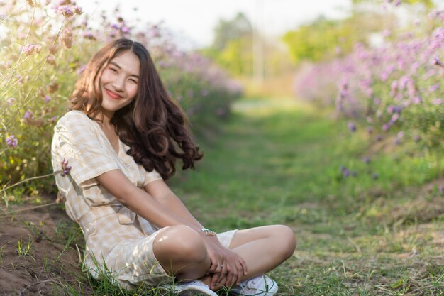 Ritratto della donna che posa nel giardino floreale