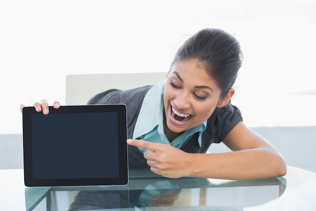 Ritratto della donna di affari sorridente che visualizza il PC del ridurre in pani