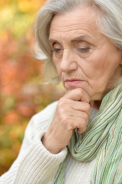 Ritratto della donna senior nel parco di autunno