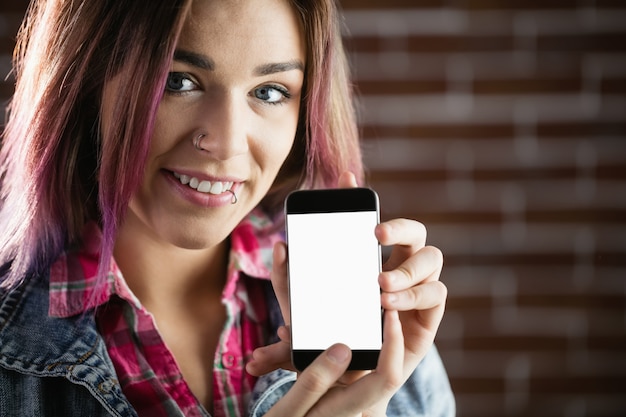 Ritratto della donna sorridente che mostra telefono cellulare