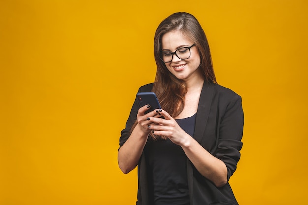 Ritratto della donna sorridente di affari in occhiali che tengono smartphone