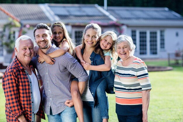 Ritratto della famiglia di diverse generazioni che sta nel giardino