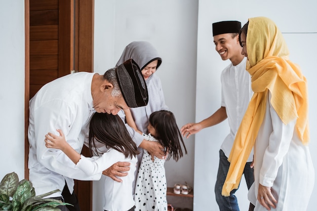 Ritratto della famiglia musulmana asiatica felice che visita i nonni su Ramadan Kareem. popolo indonesiano che celebra eid mubarak