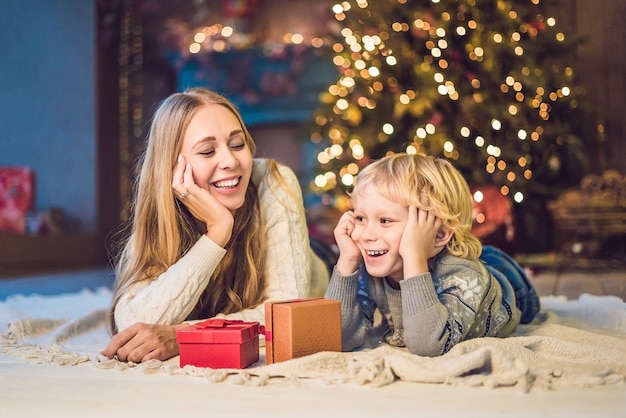 Ritratto della madre felice e del ragazzo adorabile che celebrano il Natale. Vacanze di Capodanno