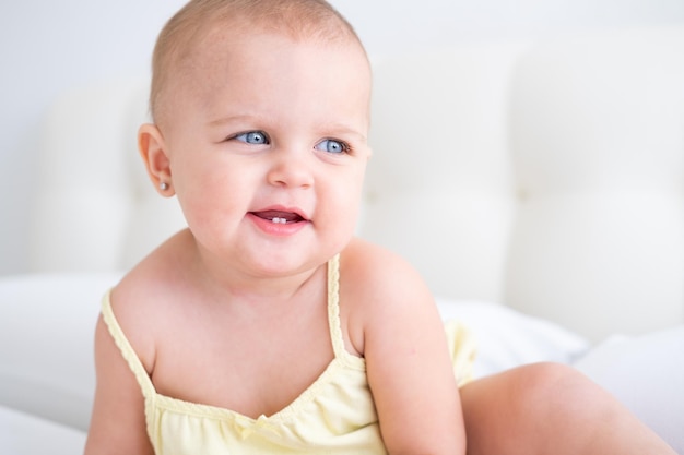ritratto della neonata sveglia che sorride con i primi denti da latte. Neonato sano