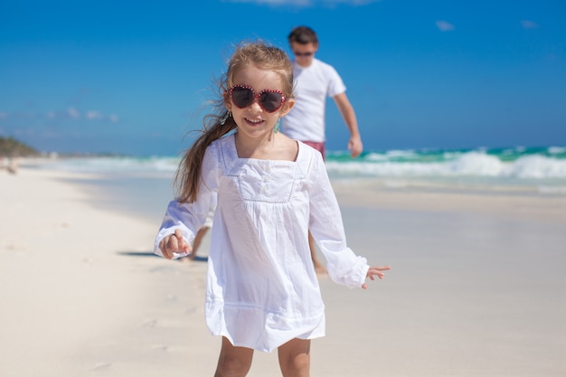 Ritratto della ragazza adorabile e di suo padre con la sorellina alla spiaggia tropicale