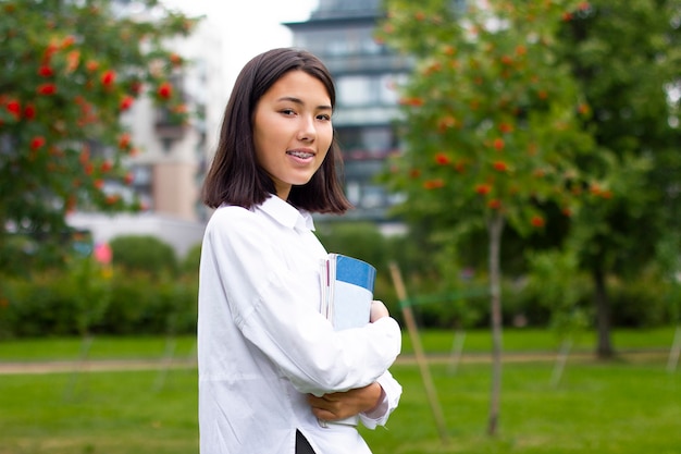 Ritratto della ragazza asiatica allegra felice all'università