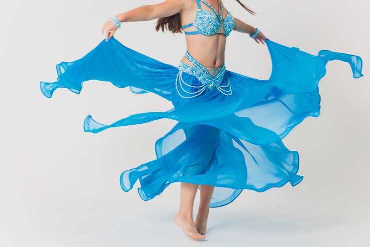 Ritratto della ragazza del ballerino di pancia in blu. isolato su bianco